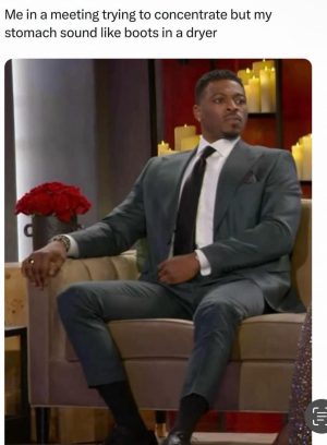 Man trying to concentrate in meeting with stomach noises